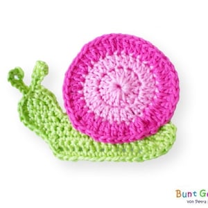 Puede incluir: Un caracol de ganchillo con una concha rosa y blanca y un cuerpo verde.