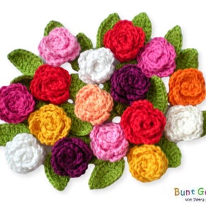 Könnte beinhalten: Ein Strauß gehäkelter Blumen in verschiedenen Farben, darunter Rosa, Rot, Orange, Gelb, Weiß und Lila. Die Blumen sind in einem Kreis mit grünen gehäkelten Blättern angeordnet.