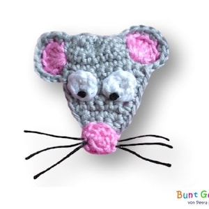 Op de afbeelding: Een grijze gehaakte muis met roze oren en neus. De muis heeft zwarte wollen snorharen en grote witte ogen met zwarte pupillen.