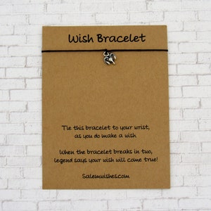 May include: A brown card with the text "Wish Bracelet" printed on it. The card has instructions on how to use the bracelet and includes the website "Salemwishes.com".