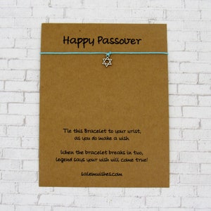 May include: A brown card with the text "Happy Passover" printed on it. A blue string bracelet with a silver Star of David charm is attached to the card. The card also includes instructions for making a wish with the bracelet. The text on the card reads: "Tie this Bracelet to your wrist, as you do make a wish. When the bracelet breaks in two, legend says your wish will come true! salemwishes.com"