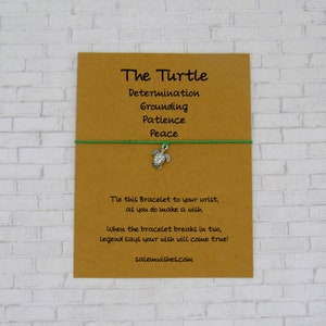 May include: A brown card with the text "The Turtle" and a list of words: Determination, Grounding, Patience, Peace. A green string bracelet with a silver turtle charm is attached to the card. The text "Tie this Bracelet to your wrist, as you do make a wish. When the bracelet breaks in two, legend says your wish will come true! salemwishes.com" is printed on the card.