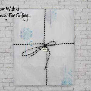 May include: A white gift bag with a black and white twine bow and a silver charm that says "wish". The bag is decorated with a watercolor design of dandelion seeds. The text "Your Wish is Ready For Gifting..." is printed on the bag.