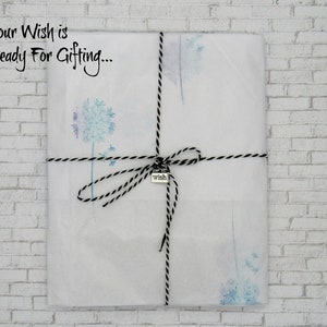May include: A white gift bag with a black and white twine bow and a silver charm that says "wish". The bag is decorated with a watercolor design of dandelion seeds. The text "Your Wish is Ready For Gifting..." is printed on the bag.