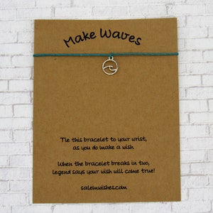 May include: A brown card with the text "Make Waves" and instructions for a wish bracelet. The bracelet is teal and has a silver charm shaped like a wave.