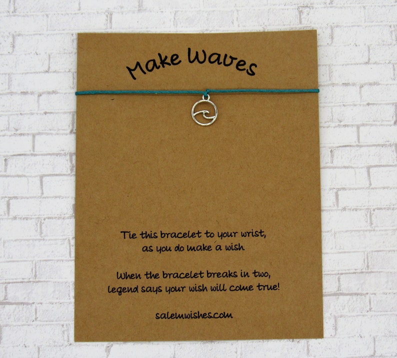 May include: A brown card with the text "Make Waves" and instructions for a wish bracelet. The bracelet is teal and has a silver charm shaped like a wave.