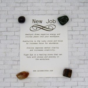 K&ouml;nnte beinhalten: Eine wei&szlig;e Karte mit dem Text "New Job" und einem Unendlichkeitszeichen. Die Karte listet die Eigenschaften von Amethyst, Aventurin, Citrin und Tigerauge-Kristallen auf. Vier Kristalle sind auf der Karte und auf einem wei&szlig;en Ziegelhintergrund abgebildet.