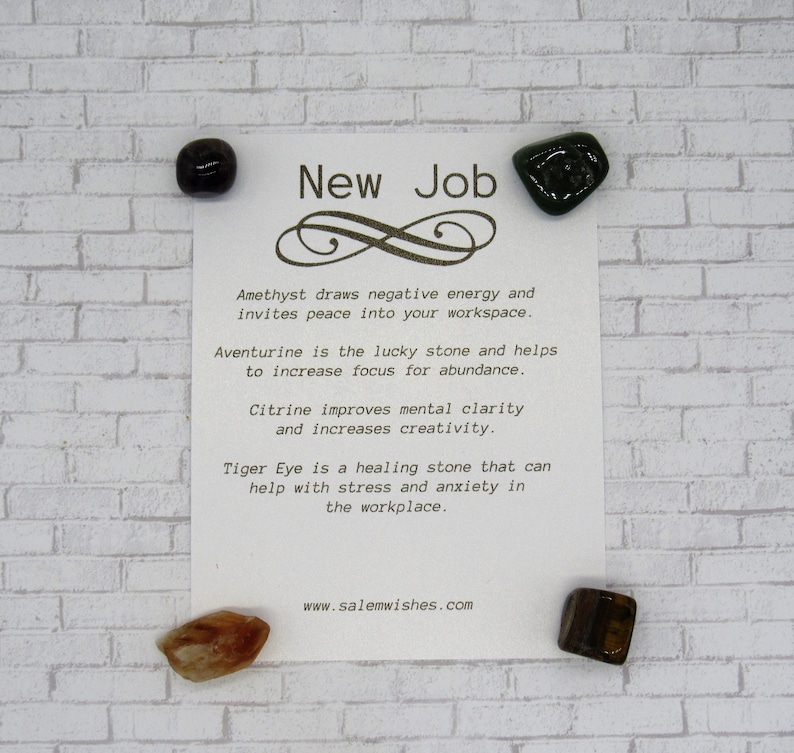 K&ouml;nnte beinhalten: Eine wei&szlig;e Karte mit dem Text "New Job" und einem Unendlichkeitszeichen. Die Karte listet die Eigenschaften von Amethyst, Aventurin, Citrin und Tigerauge-Kristallen auf. Vier Kristalle sind auf der Karte und auf einem wei&szlig;en Ziegelhintergrund abgebildet.