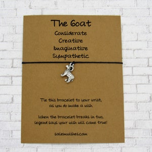 May include: A brown card with black string and a silver goat charm. The card reads "The Goat" and lists the following traits: "Considerate, Creative, Imaginative, Sympathetic". The card also says "Tie this bracelet to your wrist, as you do make a wish. When the bracelet breaks in two, legend says your wish will come true!" and "salemwishes.com".