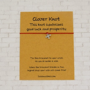 May include: A red string bracelet with a silver clover knot charm. The card attached to the bracelet reads "Clover Knot This knot symbolizes good luck and prosperity Tie this bracelet to your wrist, as you do make a wish When the bracelet breaks in two, legend says your wish will come true! Salemwishes.com"