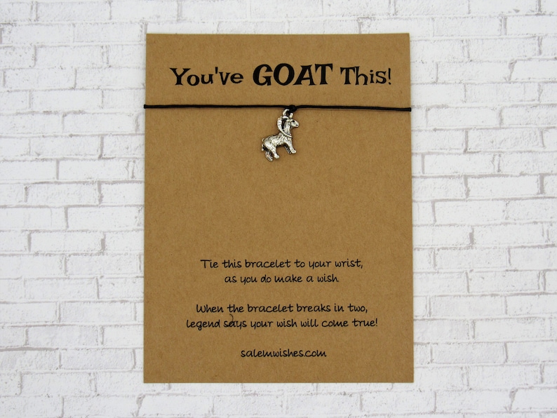 May include: A brown card with the text "You've GOAT This!" and a silver goat charm attached to a black string. The card also includes the text "Tie this bracelet to your wrist, as you do make a wish. When the bracelet breaks in two, legend says your wish will come true! salemwishes.com"