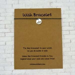 May include: A brown card with the text "Wish Bracelet" printed on it. The card has instructions for making a wish and tying a bracelet. The text reads: "Tie this bracelet to your wrist, as you do make a wish. When the bracelet breaks in two, legend says your wish will come true! salemwishes.com"