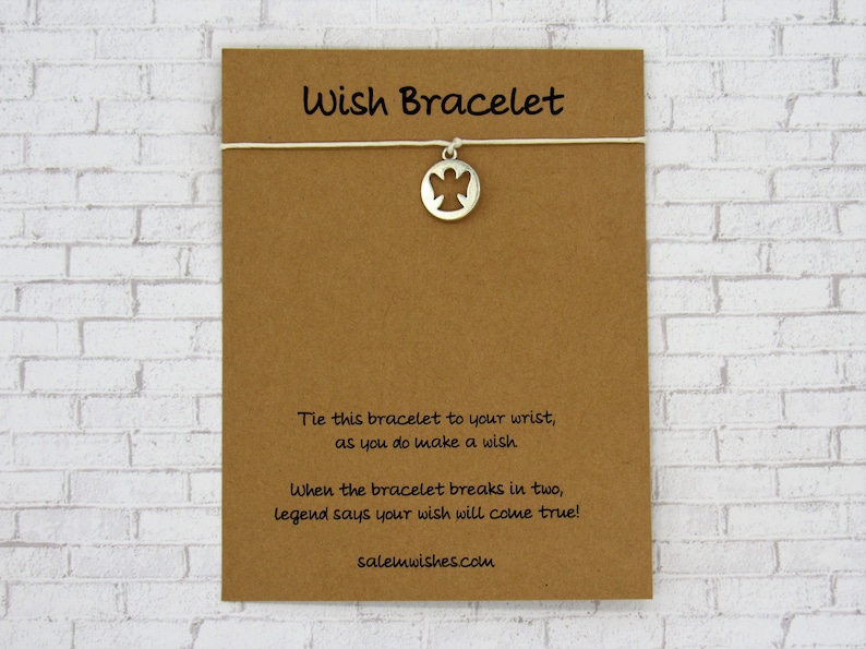 May include: A brown card with the text "Wish Bracelet" printed on it. The card has instructions on how to make a wish with the bracelet. The bracelet has a silver charm with an angel cutout.