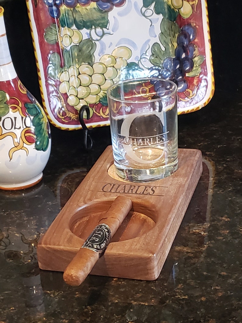 Peut inclure: Un porte-cigare et porte-verre en bois avec un verre &agrave; whisky et un repose-cigare. Le porte-cigare est personnalis&eacute; avec le nom "CHARLES".