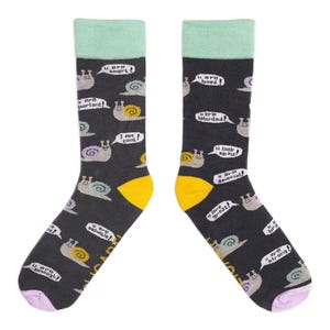 Könnte beinhalten: Ein Paar dunkelgraue Socken mit mintgrüner Manschette, gelber Ferse und lila Spitze. Die Socken zeigen Schneckenillustrationen mit Sprechblasen mit positiven Aussagen wie "U are smart!" und "I am cool!"