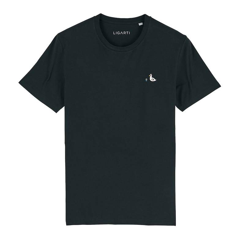 May include: A dark navy blue t-shirt with a small white embroidered bird design on the chest. The text "LIGARTI" is printed on the shirt.