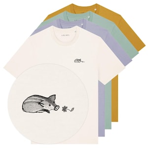 Könnte beinhalten: Eine Auswahl an Rundhals-T-Shirts in Creme, Lavendel, Mintgrün und Senfgelb. Jedes Shirt hat ein kleines gesticktes Design eines Ferkels und einer Blume. Der Markenname "LIGARTI" ist auf den Shirts aufgedruckt.