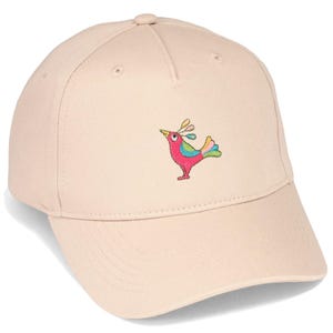 Könnte beinhalten: Eine hellbeige Baseballkappe mit einer gestickten Grafik eines kleinen Vogels. Der Vogel ist in leuchtenden Farben wie Pink, Blau, Gelb und Grün gehalten, mit einem auffälligen Auge und einem Kamm aus drei ovalen Formen auf dem Kopf.
