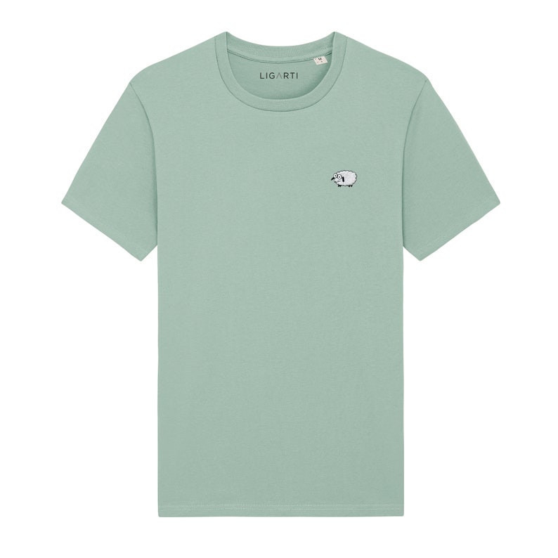 K&ouml;nnte beinhalten: Hellgr&uuml;nes T-Shirt mit einem kleinen, gestickten Schafmotiv auf der Vorderseite. Das Shirt hat einen Rundhalsausschnitt und kurze &Auml;rmel. Der Markenname "LIGARTI" ist auf dem Kragen aufgedruckt.