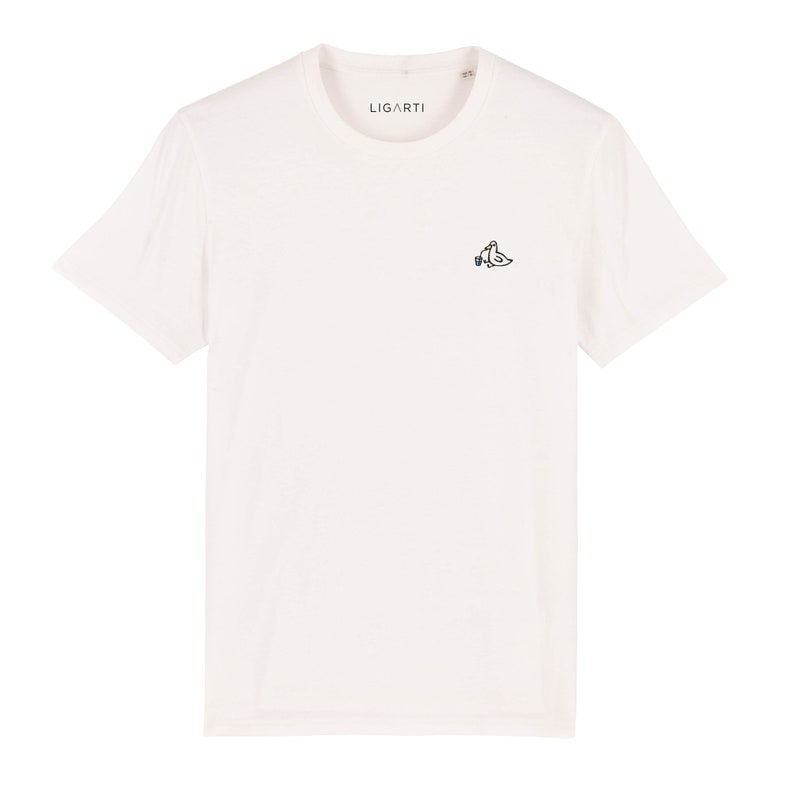 May include: White t-shirt with a small embroidered design of two birds holding a bottle of wine. The text "LIGARTI" is printed on the shirt.