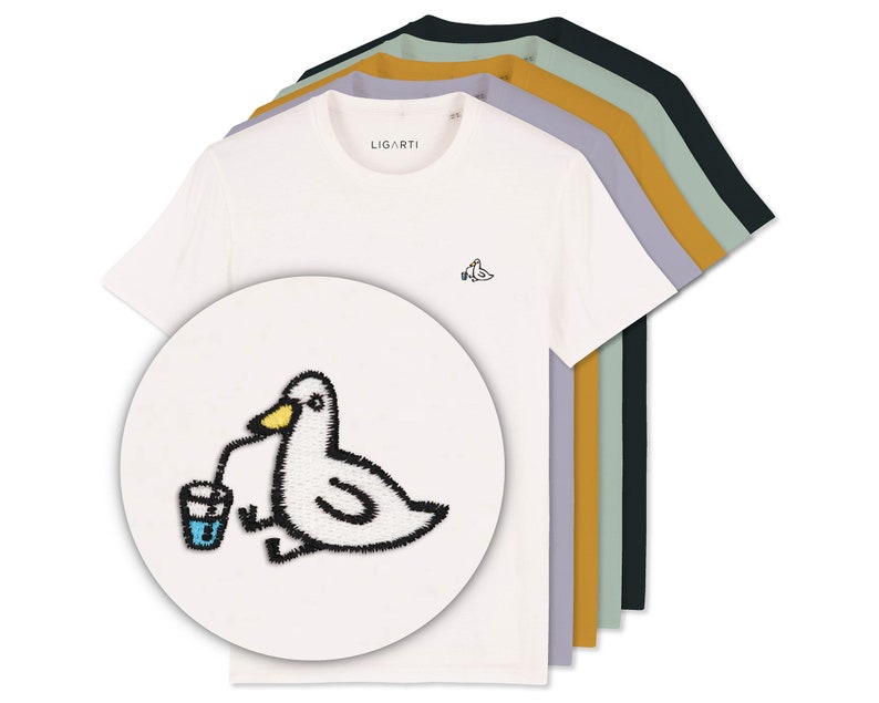 May include: A set of five t-shirts in different colors, featuring a white t-shirt with an embroidered image of a cartoon duck drinking from a glass with a straw. The text "LIGARTI" is printed on the white t-shirt.