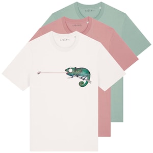 Könnte beinhalten: Ein Stapel aus drei kurzärmeligen T-Shirts mit Rundhalsausschnitt in Weiß, Altrosa und Salbeigrün. Das weiße T-Shirt zeigt eine grafische Illustration eines grünen Chamäleons auf einem Ast, das eine Fliege mit der Zunge fängt. LIGARTI-Label.