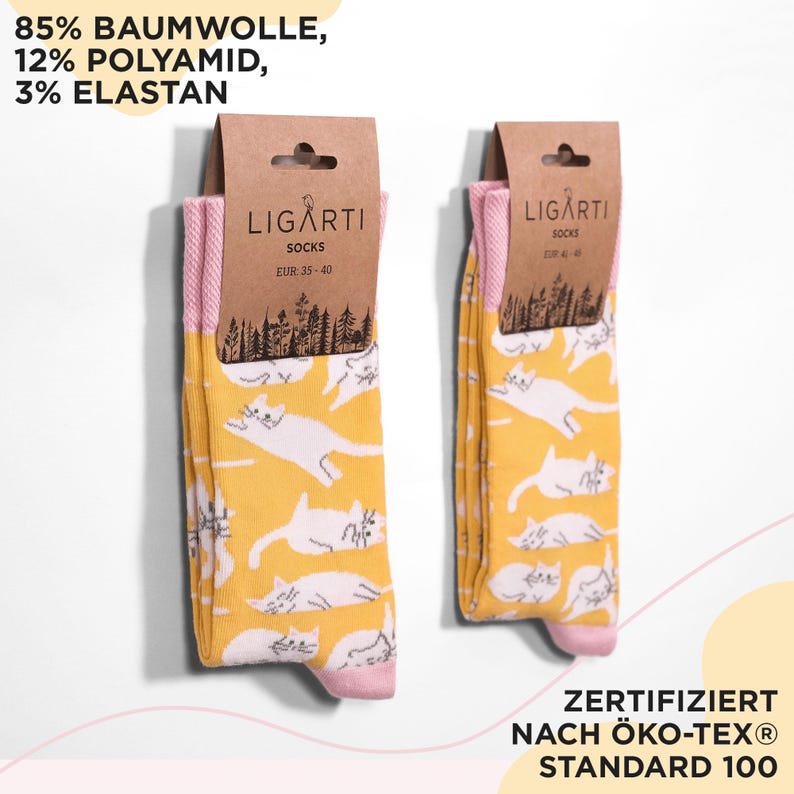 May include: Two pairs of socks with a yellow background and white cat pattern. The socks have pink cuffs and toes. The packaging includes the brand name "LIGARTI" and the text "SOCKS EUR 35-40". The socks are made of 85% cotton, 12% polyamide, and 3% elastane.