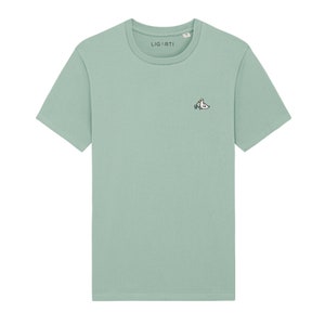 May include: A light green t-shirt with a small embroidered design of two birds on the left chest. The text "LIGARTI" is visible on the shirt.