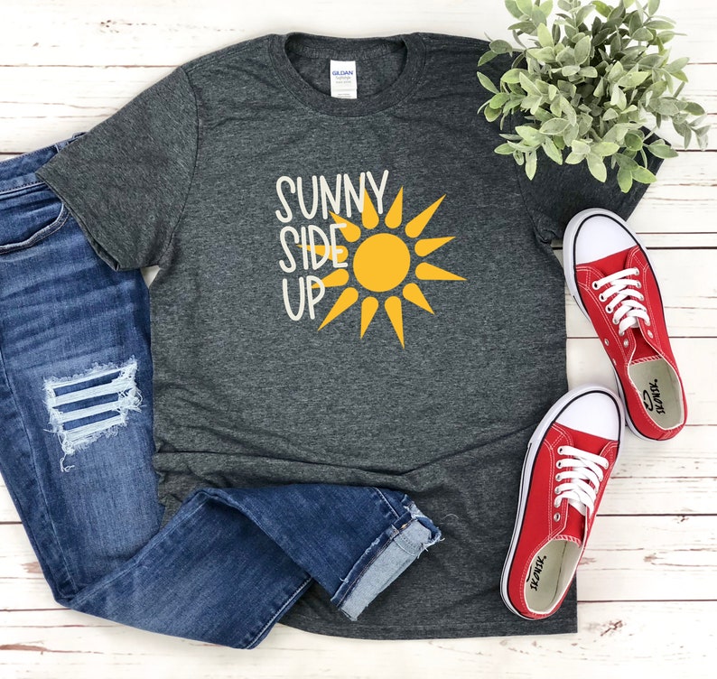 May include: A dark gray t-shirt with the text "Sunny Side Up" in white and a yellow sun graphic.