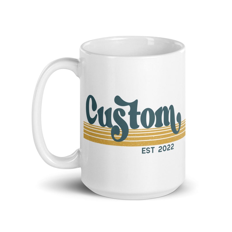 May include: White ceramic mug with a teal blue and gold design. The design features the word "Custom" in a retro font with gold stripes and the text "EST 2022" below.