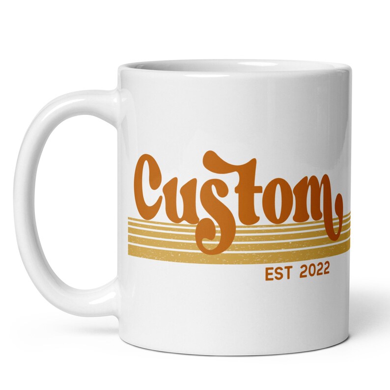 May include: White ceramic mug with an orange and brown graphic that says "Custom EST 2022".