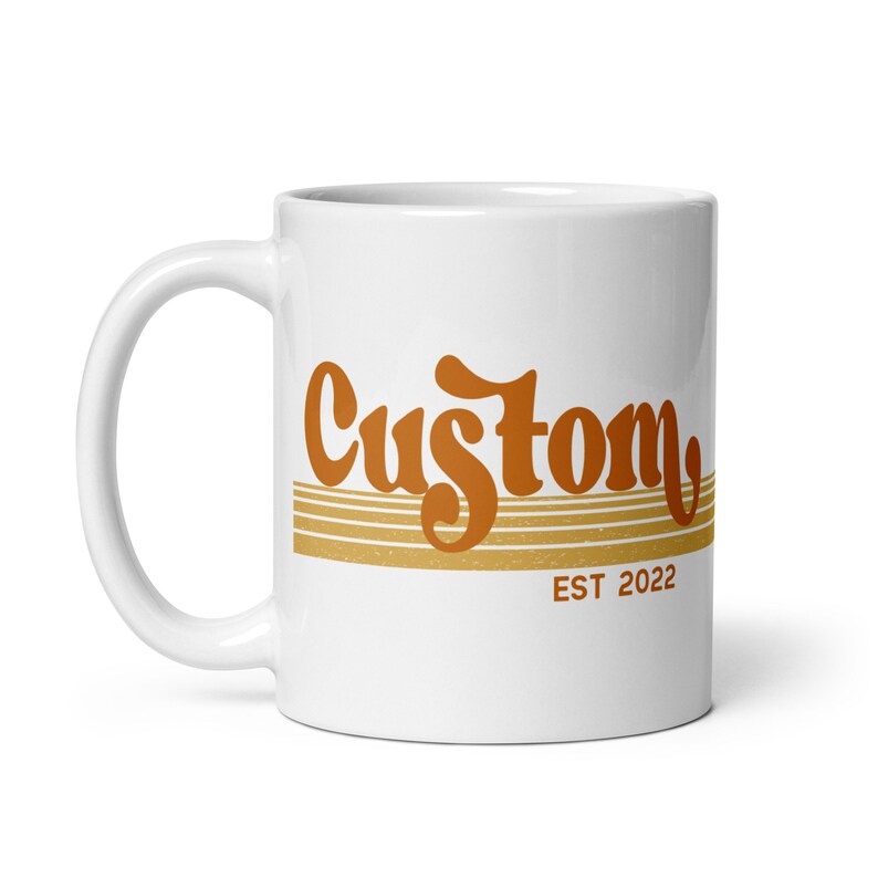 May include: White ceramic mug with a brown and orange graphic that says "Custom EST 2022".