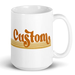 May include: White ceramic coffee mug with a brown "Custom" graphic in a retro font with gold stripes.