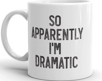 Op de afbeelding: Witte keramische koffiemok met zwarte tekst die "So Apparently I'm Dramatic" luidt.