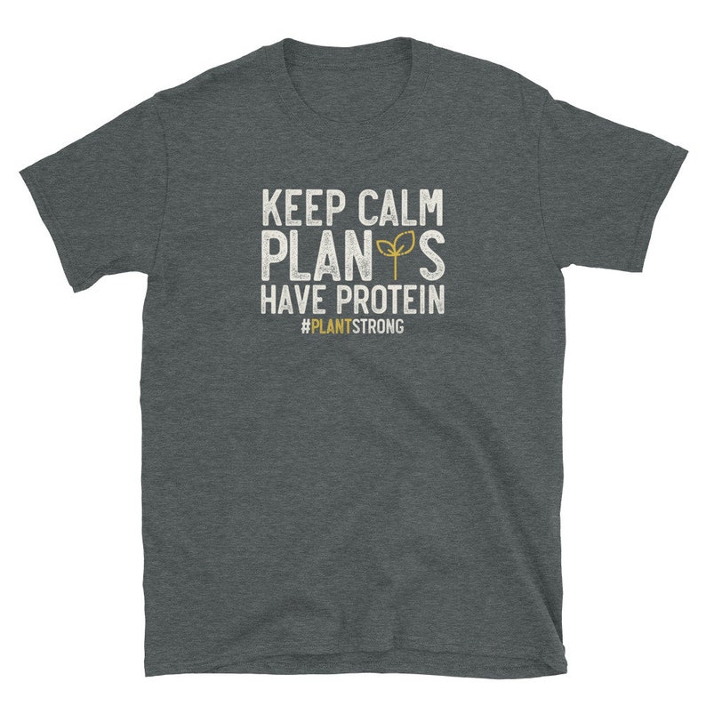 May include: A dark heather grey t-shirt with a white graphic that says "Keep Calm Plants Have Protein #PlantStrong".