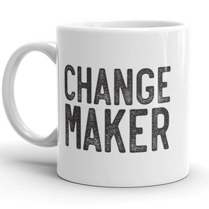 May include: White ceramic coffee mug with a black text design that reads "CHANGE MAKER".