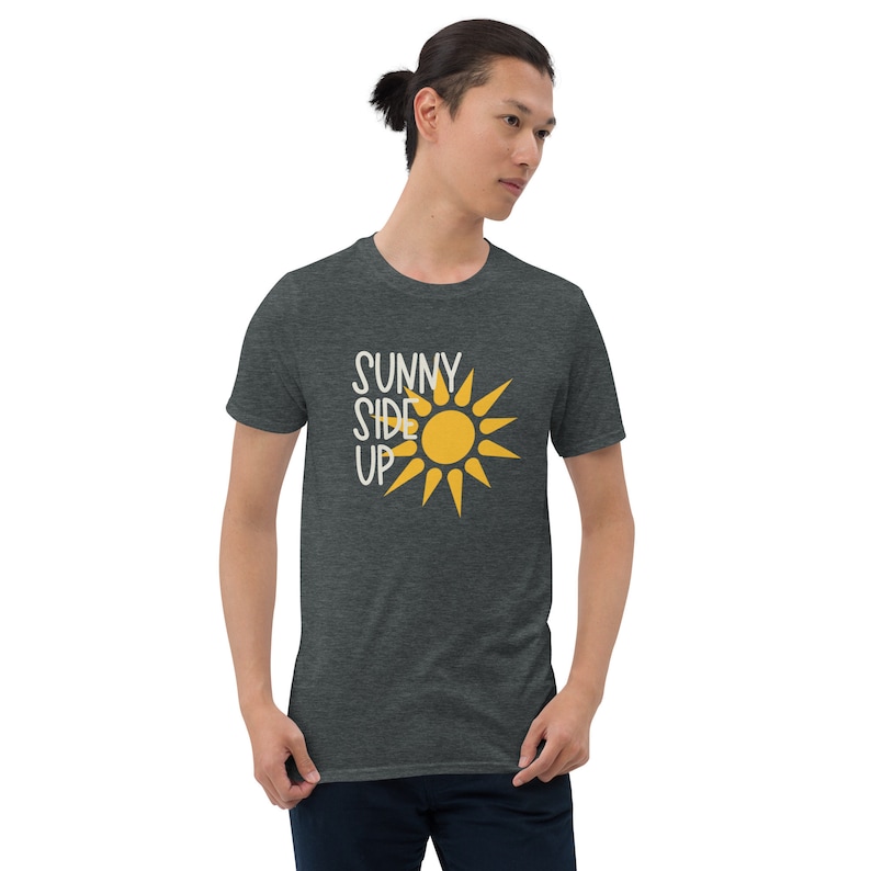 May include: A dark heather grey t-shirt with a white graphic of a sun and the text "SUNNY SIDE UP".