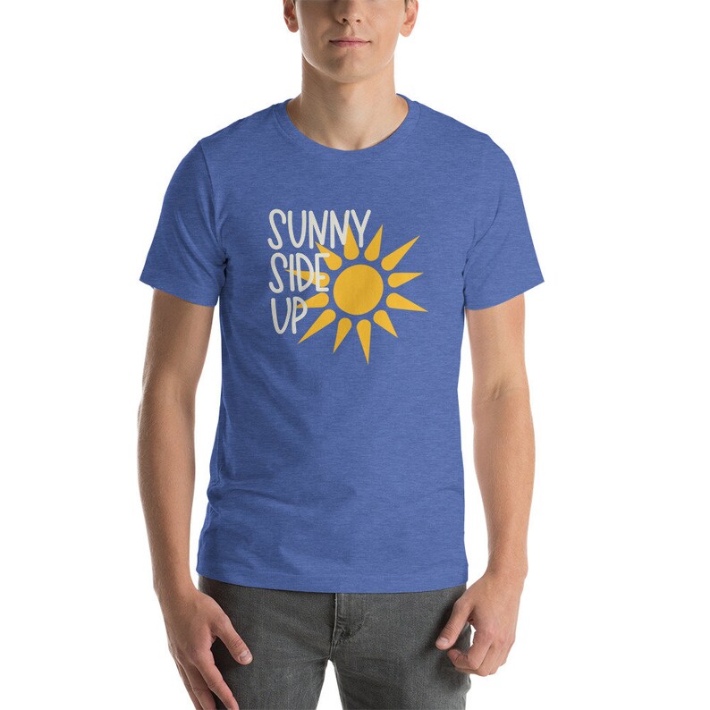 May include: A blue heather t-shirt with a white graphic of a sun and the text "SUNNY SIDE UP".