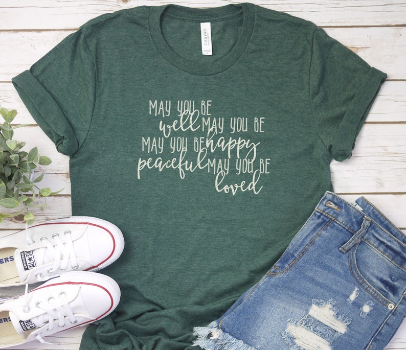 May include: A green t-shirt with the text "MAY YOU BE well MAY YOU BE peaceful MAY YOU BE loved" printed in white on the front.