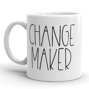 May include: White ceramic coffee mug with black text that reads "CHANGE MAKER".