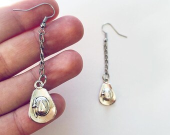 May include: A pair of silver dangle earrings with a cowboy hat charm. The earrings are on a chain and have a hook closure.