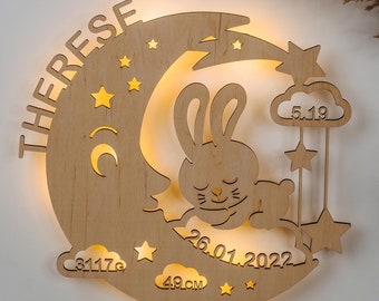 May include: Wooden nursery night light shaped like a crescent moon with a sleeping bunny. The name "THERESE" is arched above the moon. Includes stars, clouds, and the date "26.01.2022". The baby's weight is 3117g and length is 49cm.