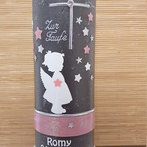 Pu&ograve; includere: Una candela grigia con una silhouette di angelo rosa e bianca, una croce e stelle. La candela ha un nastro rosa con il testo "Zur Taufe" e "Romy 04.09.2021".