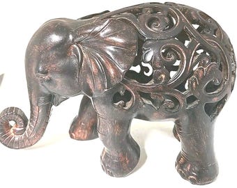Gesneden olifantensculptuur met open, sierlijke, donkerhouten slurf die naar boven gebogen is.
