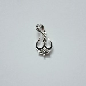 May include: Silver pendant charm with a detailed design of a stylized trident. The pendant has a loop at the top for attaching to a chain or bracelet.