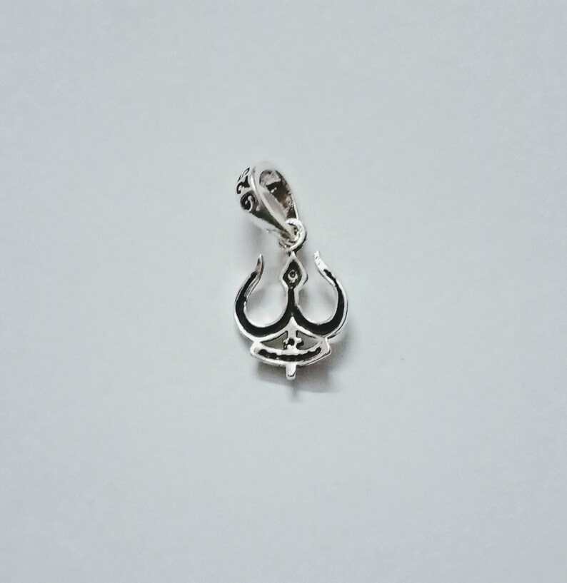 May include: Silver pendant charm with a detailed design of a stylized trident. The pendant has a loop at the top for attaching to a chain or bracelet.