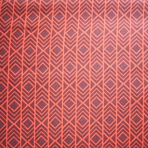 Könnte beinhalten: Nahaufnahme eines Stoffes mit einem sich wiederholenden geometrischen Muster. Das Design zeigt eine Reihe von orangefarbenen Rauten, die auf einem dunkelbraunen Hintergrund orangefarben umrandet sind. Die Rauten sind in vertikalen Spalten angeordnet.