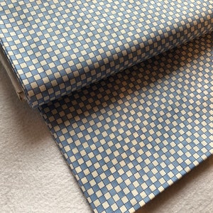 Könnte beinhalten: Blau-weiß kariertes Stoff mit einem kleinen, feinen Muster. Der Stoff ist in der Hälfte gefaltet und die Kanten sind sichtbar.