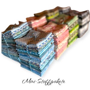 Könnte beinhalten: Ein Stapel Stoffpakete in verschiedenen Farben und Mustern, darunter Blau, Rosa, Grün und Weiß. Die Pakete sind mit Schnur gebunden und mit "Mini-Stoffpakete" beschriftet.