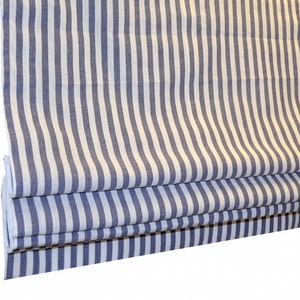 May include: A white and blue striped roman blind with a blue stripe width of approximately 2.5 cm.